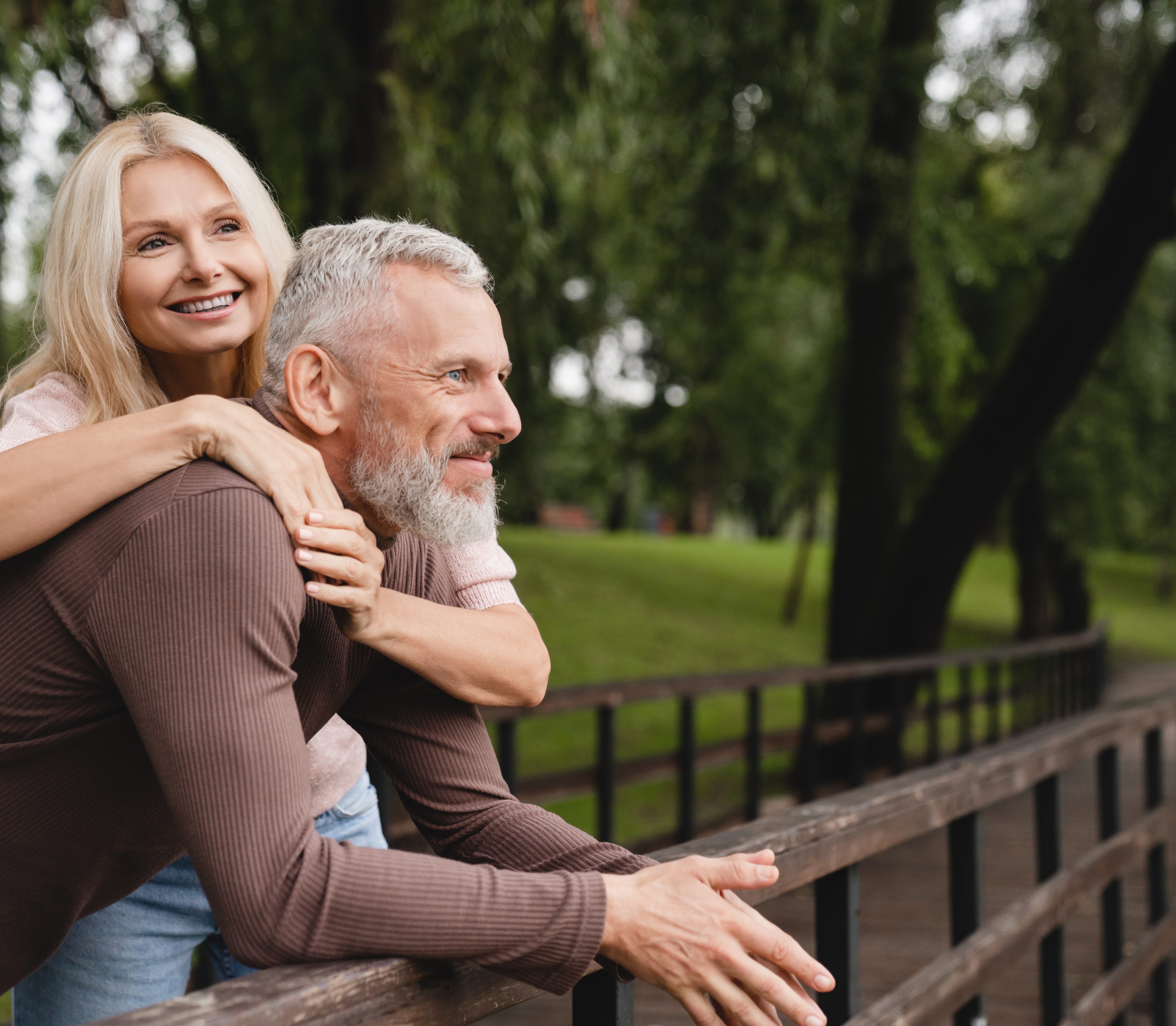 Couple in their 50s smiling together outdoors, illustrating the feel-better-again goal of peptide therapy.